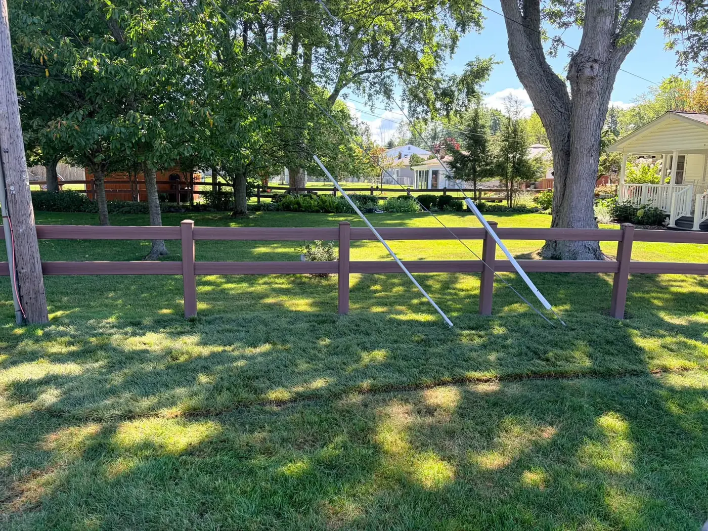 Freshly cut, cleaned-up backyard with a split-rail fence, a Stone Mountain Lawn Care job