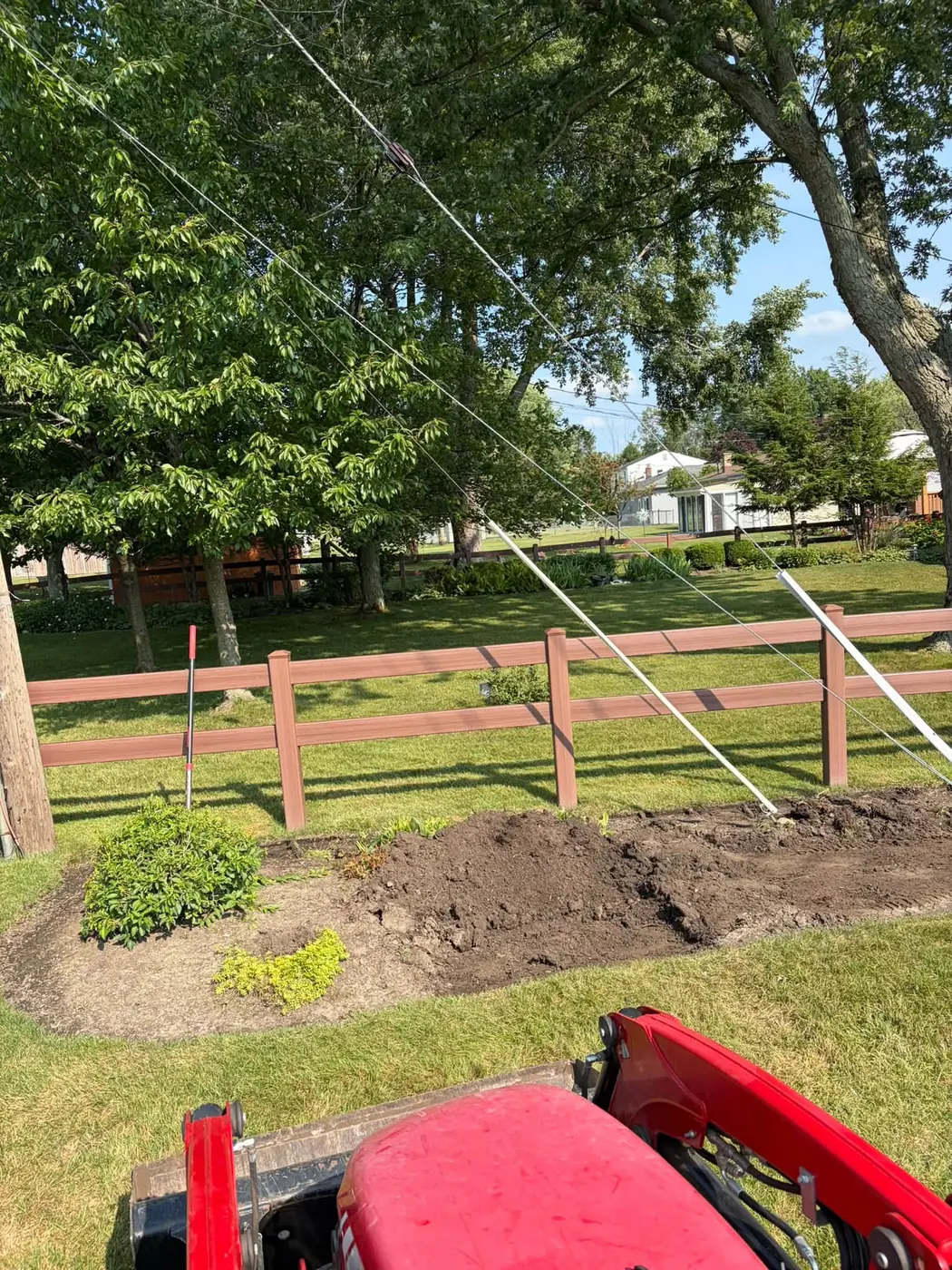 Freshly turned planting bed along a wooden fence, a Stone Mountain Lawn Care job